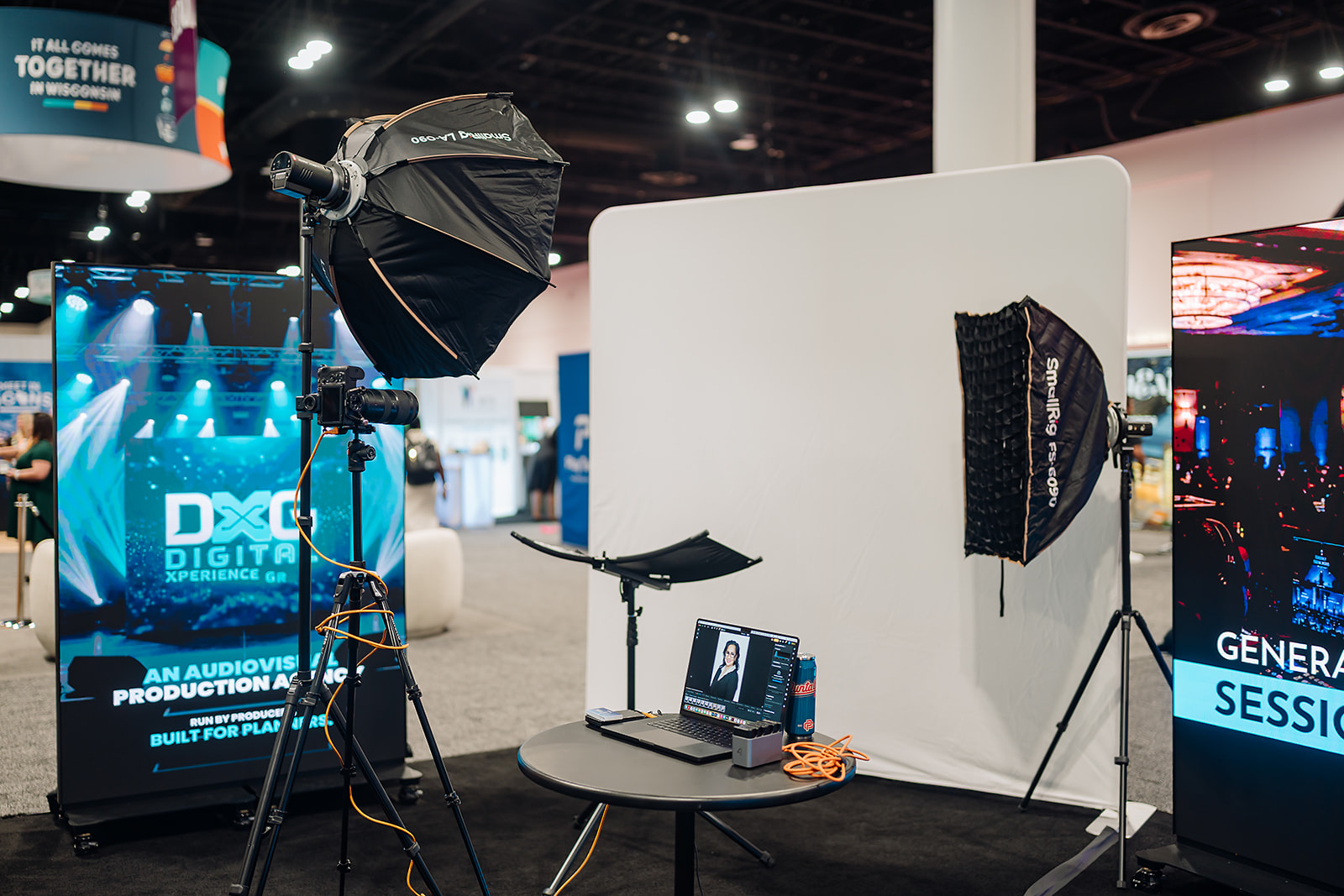 Professional headshot lounge setup with backdrop, softboxes, and tethered laptop